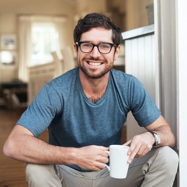 man smiling with cup of coffee