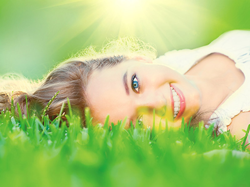 women laying down on a grass field